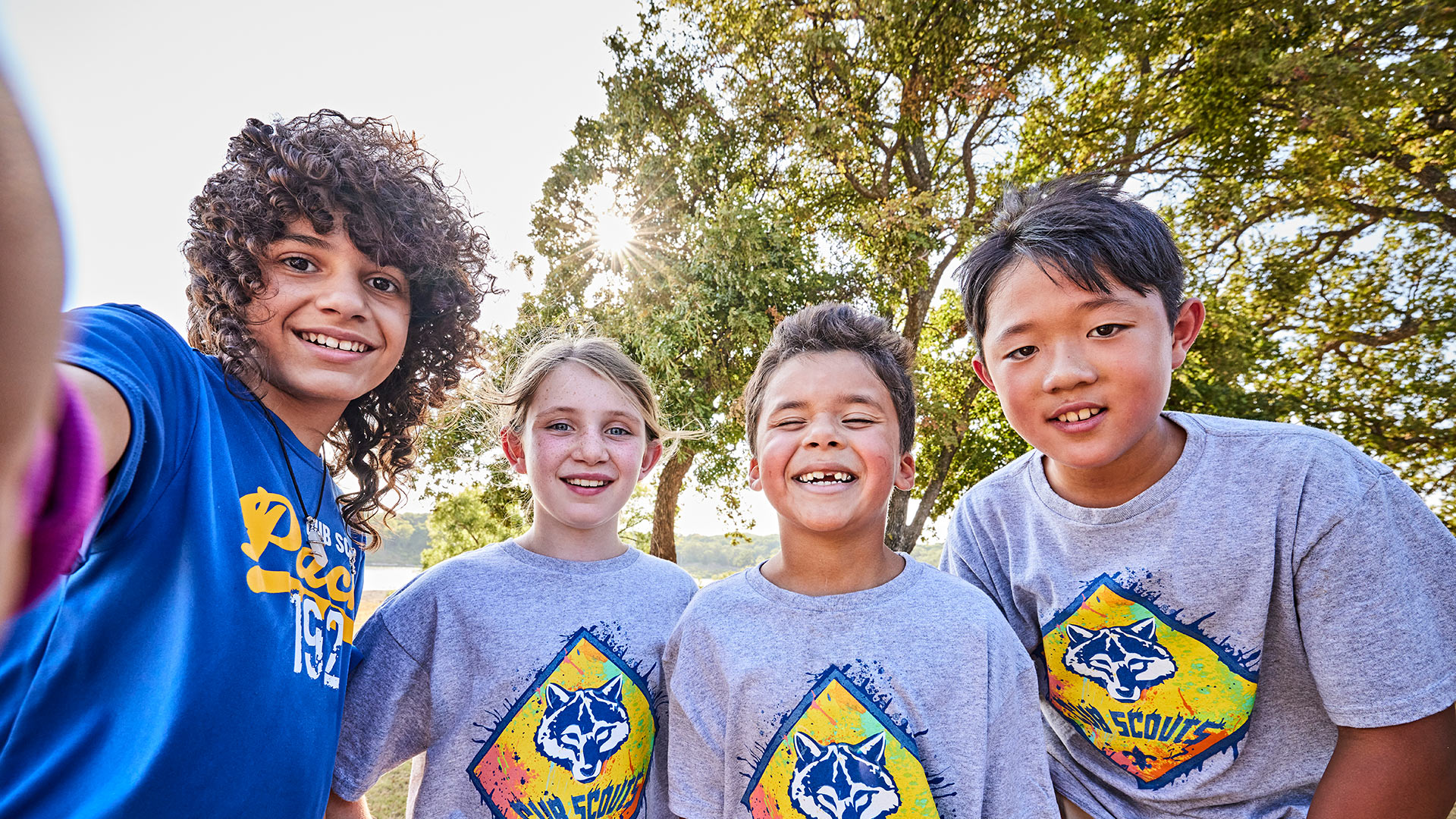 Four smiling cub scouts outdoors