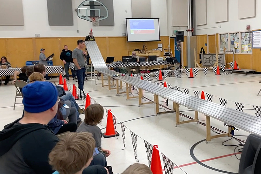 Pinewood derby cars race down the track